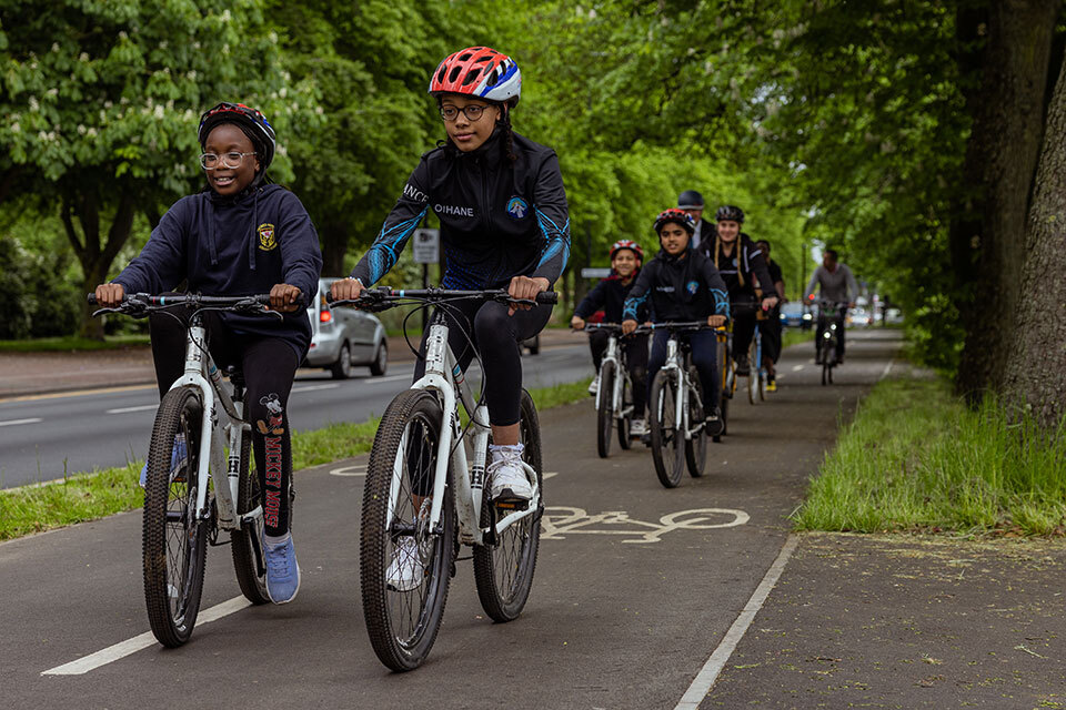 Young people cycling on a segregated route in England